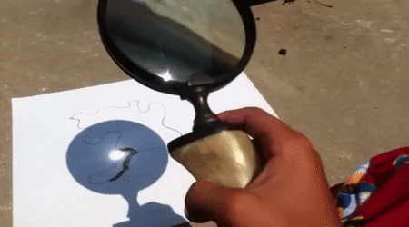 magnifying glass with sunlight on a piece of paper
