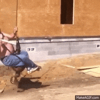 a man swinging on top of a wrecking ball