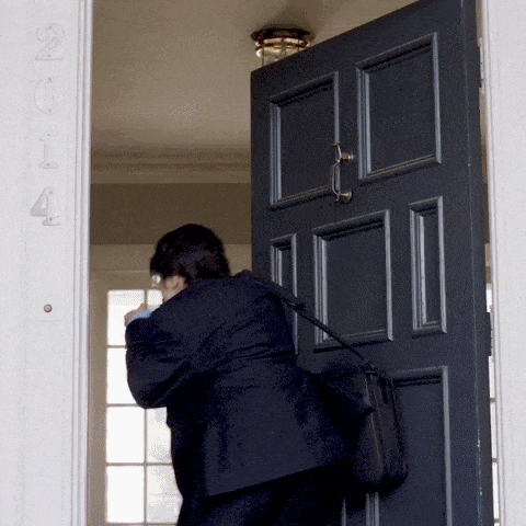 a man chugging coffee as he walks out the front door