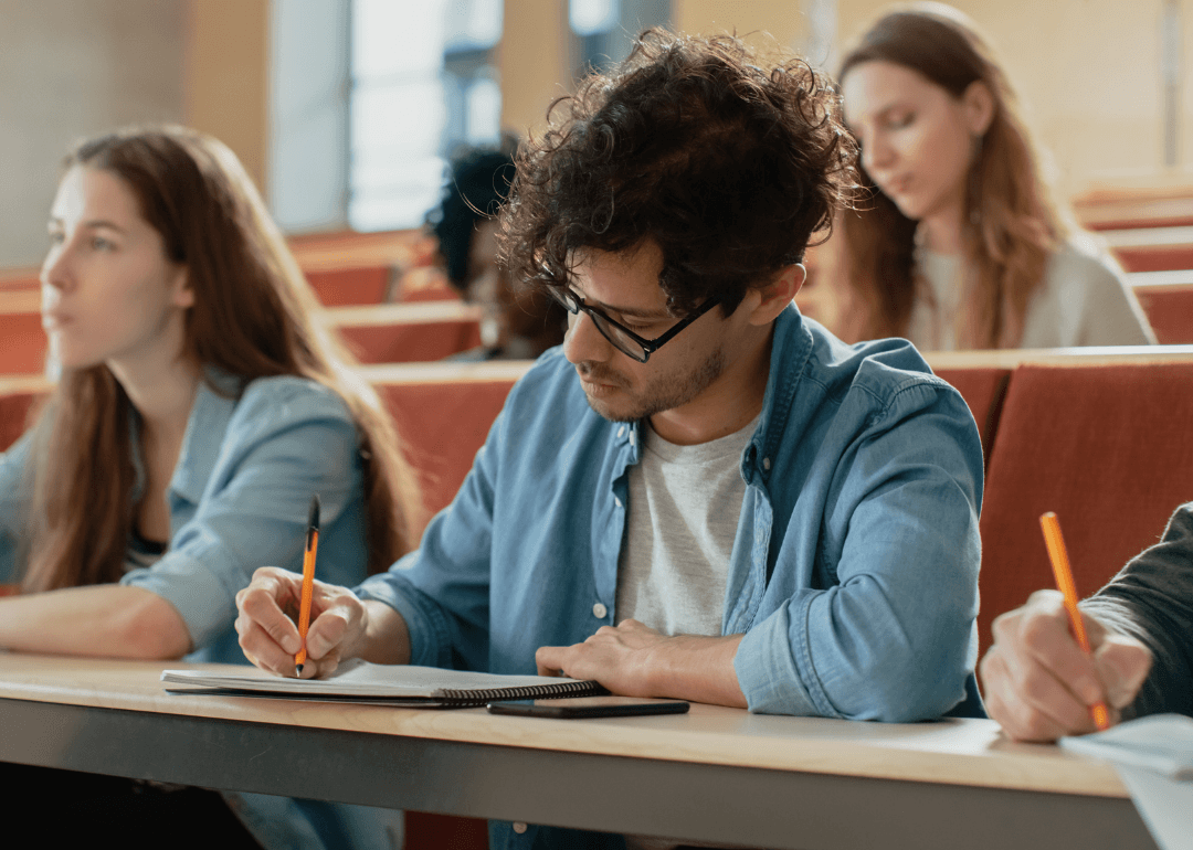 Ein Schüler schreibt Notizen mit einem Stift