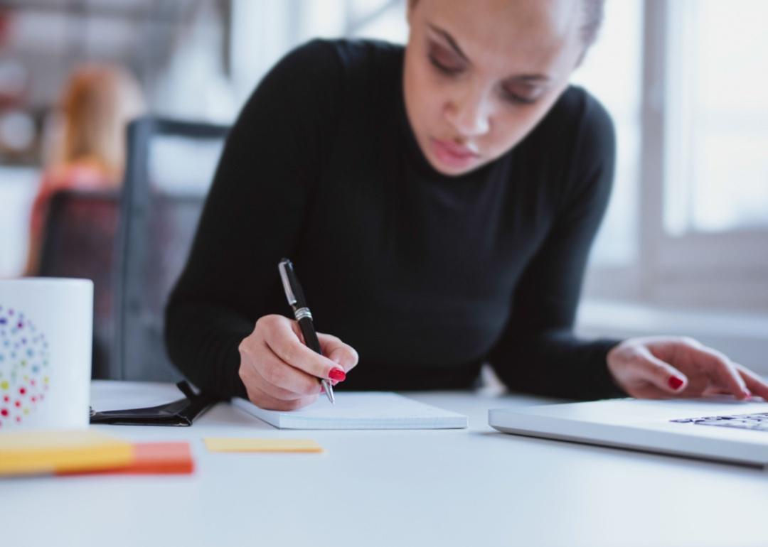 Een vrouw schrijft op een blocnote