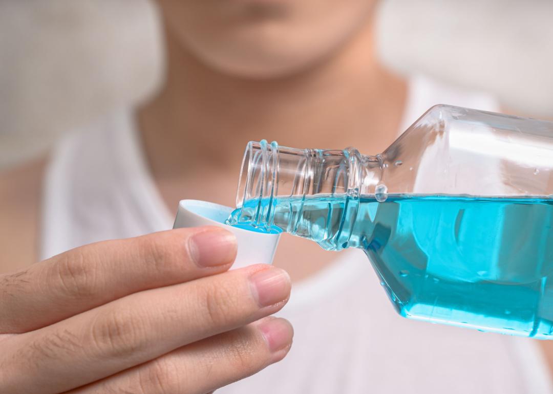 Seseorang sedang menuangkan Listerine ke dalam botol