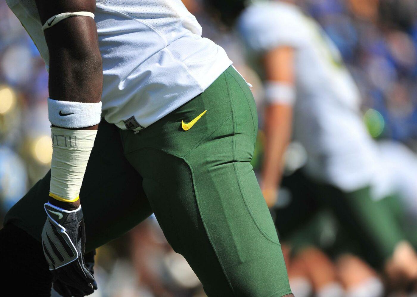 Collegiate athlete wearing green Nike pants 