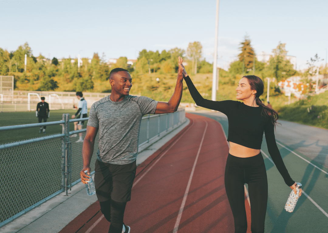 Two people high-fiving each other on the track