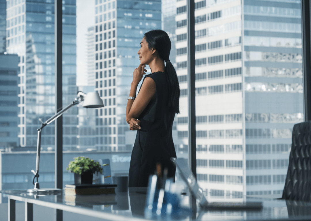 Eine Frau, die an ihrem Bürotisch nachdenkt