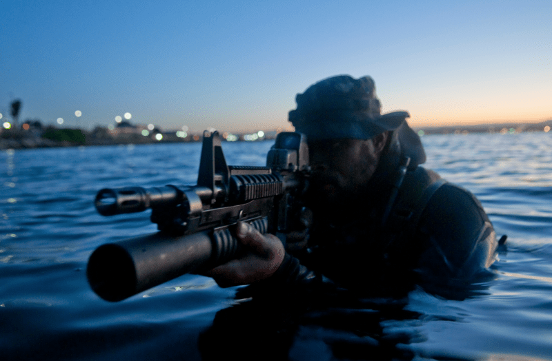 Een Navy SEAL staat in met haaien besmet water