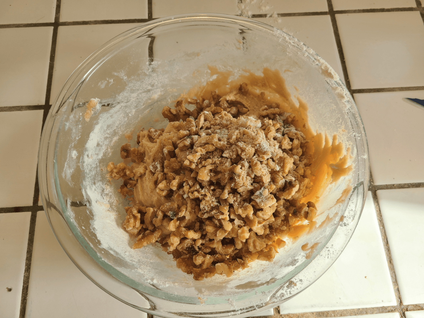 Adding chopped walnuts to mixing bowl