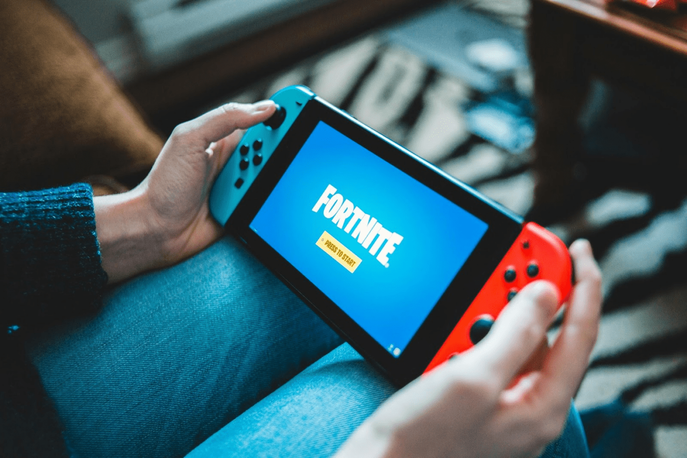 Person playing Fortnite on a gaming device 